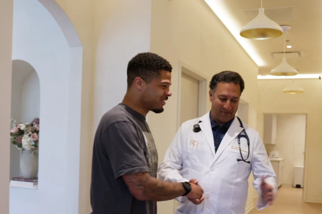 Physician welcoming a patient in the hallway at Renova Total Health in Carmel, Indiana