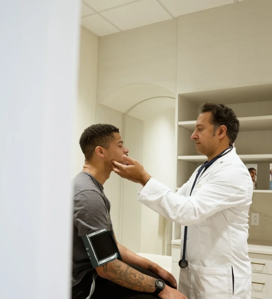 Physician examining a patient's neck and throat at Renova Total Health