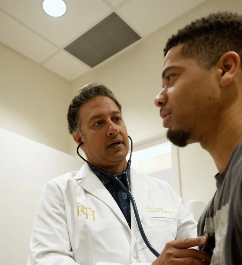 Internal medicine physician in an RTH coat speaking with a patient