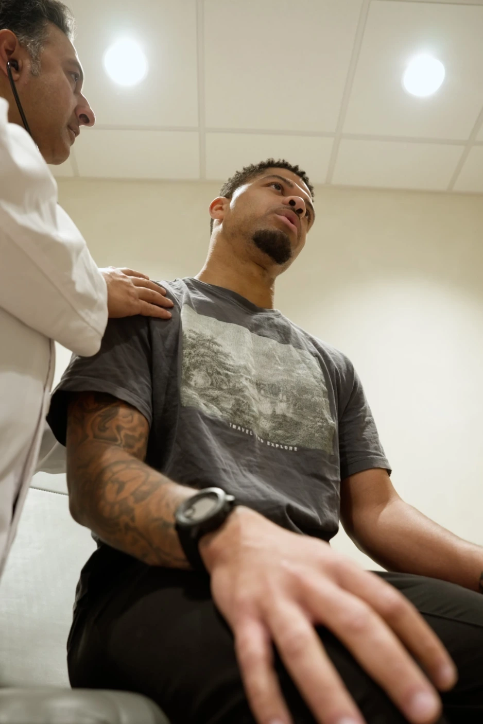 Physician examining a seated patient at Renova Total Health