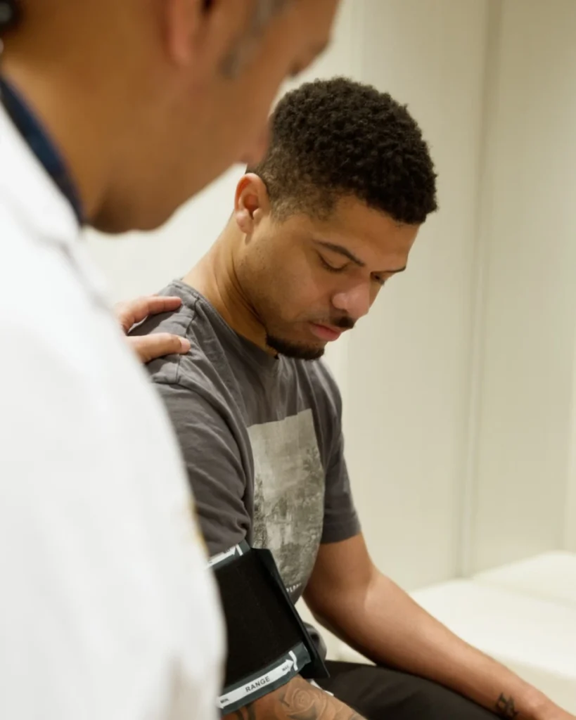 Physician reassuring a seated patient with a hand on his shoulder at Renova Total Health