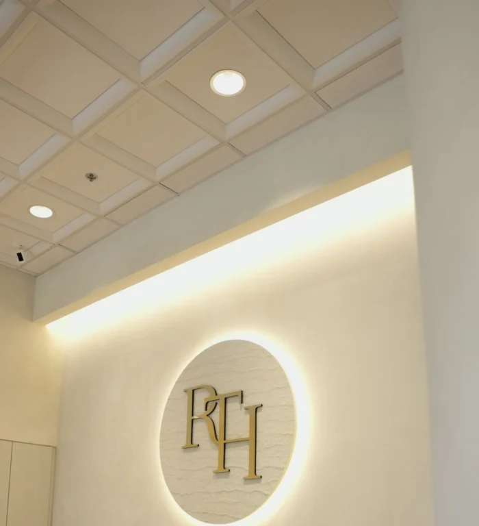 Illuminated RTH logo on the reception wall at Renova Total Health in Carmel, Indiana