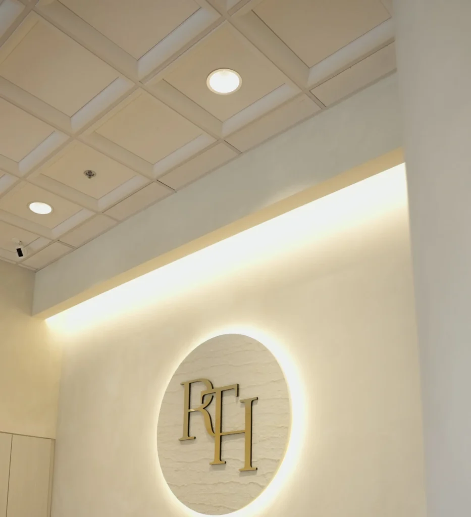 Illuminated RTH logo on the reception wall at Renova Total Health in Carmel, Indiana