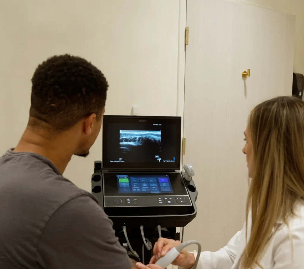 Provider performing an ultrasound joint assessment on a patient's arm at Renova Total Health